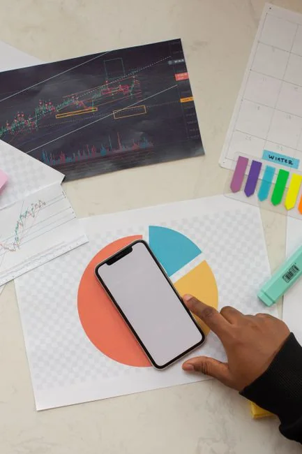 Équipe examinant des graphiques financiers et des données numériques sur des tablettes dans un environnement de bureau.