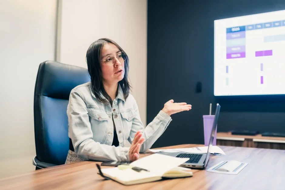 Un espace de travail moderne montrant des mains qui analysent des données marketing sur un ordinateur portable et des documents papier.